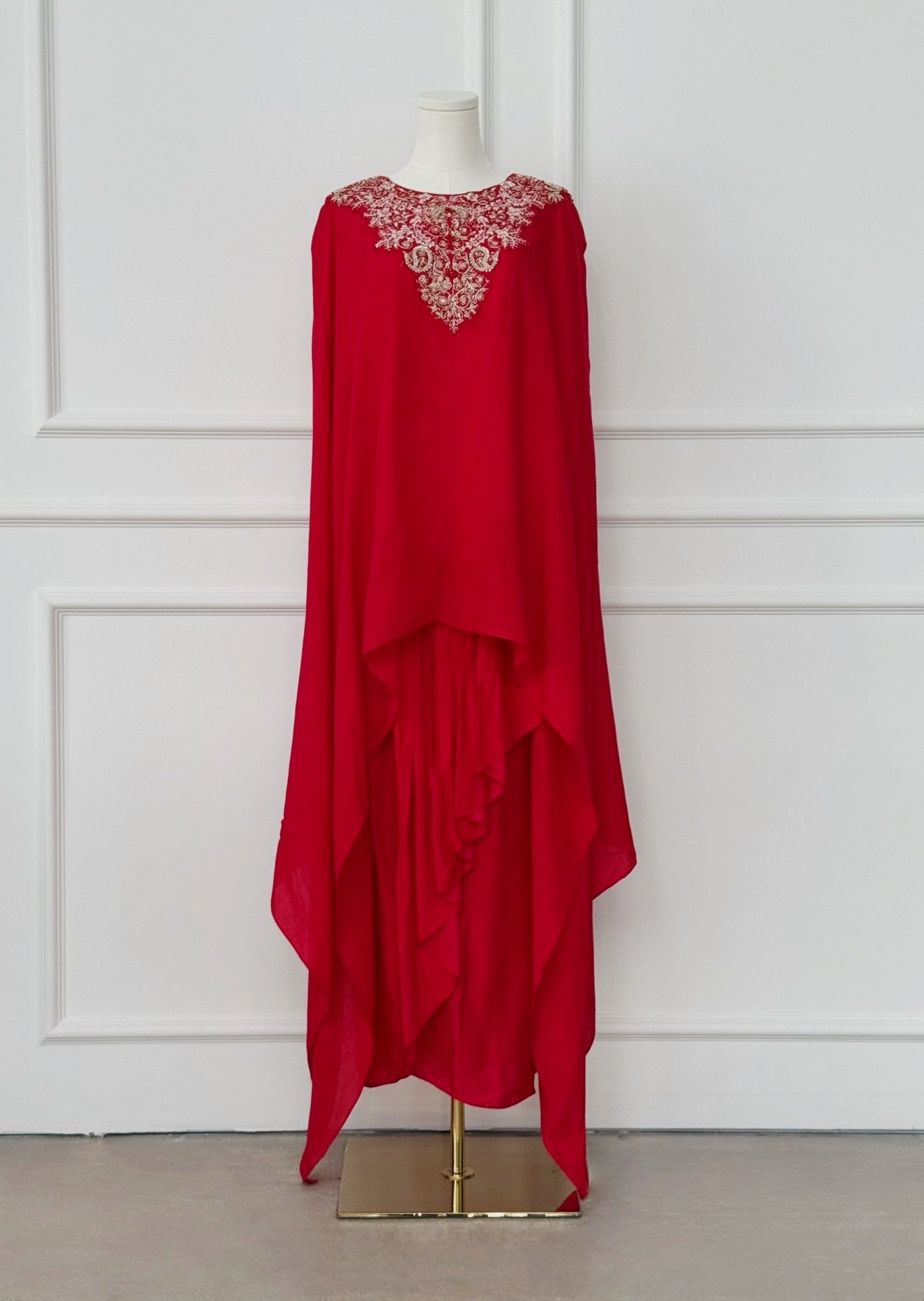 Red kaftan-style dress with intricate floral embroidery on the neckline and a flowing asymmetrical layered design, ideal for festive and formal occasions