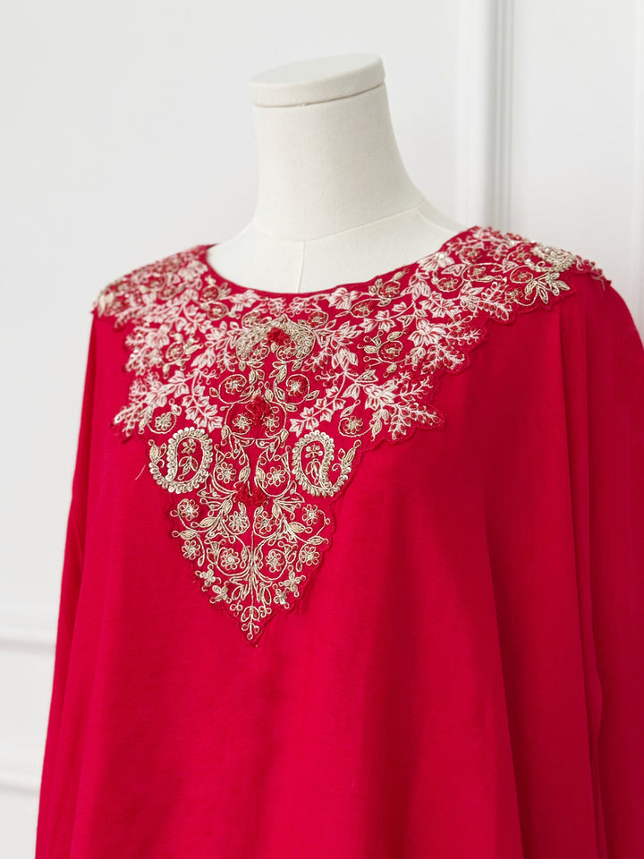 Red kaftan-style dress with intricate floral embroidery on the neckline and a flowing asymmetrical layered design, ideal for festive and formal occasions